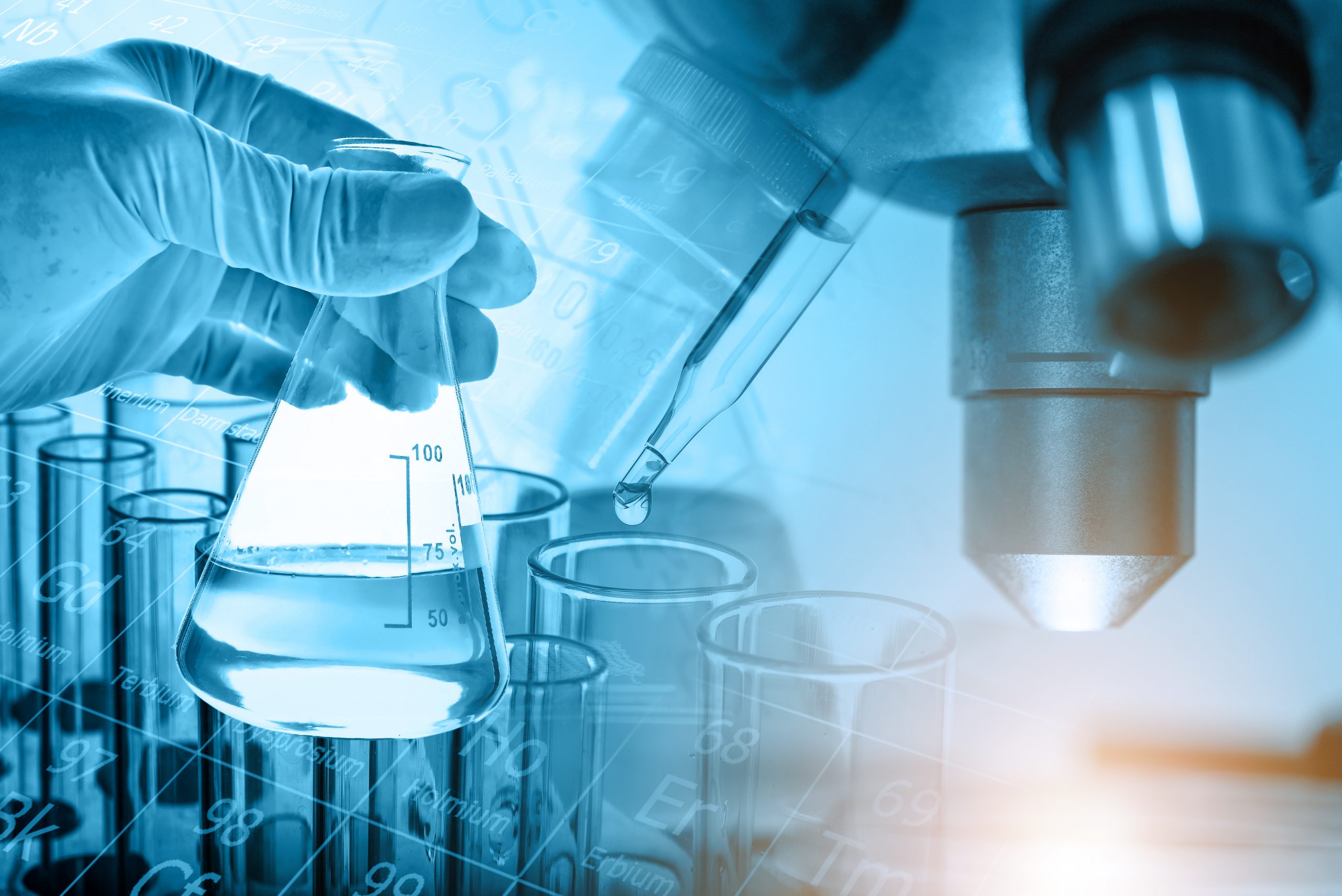 Flask in scientist hand with microscope and lab glassware background